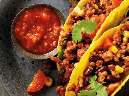 une-assiette-avec-des-tacos-et-de-la-salsa-dessus