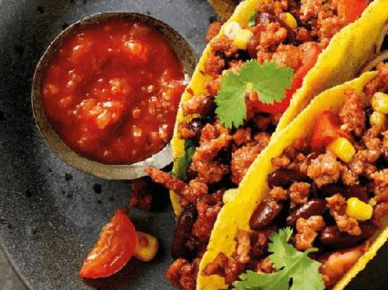 une-assiette-avec-des-tacos-et-de-la-salsa-dessus